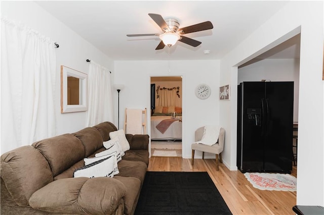 living room with ceiling fan and light hardwood / wood-style flooring