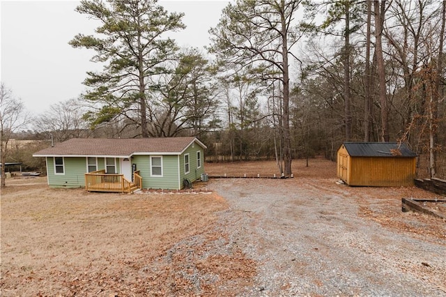 view of front facade featuring a wooden deck and a shed