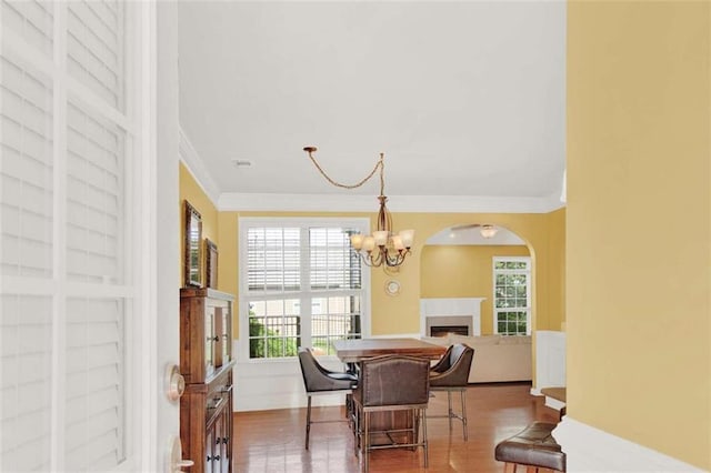 2685 Sardis Chase Ct, Buford, GA 30519 - dining room featuring a fireplace, ornamental molding, a chandelier, healthy amount of natural light, and arched walkways