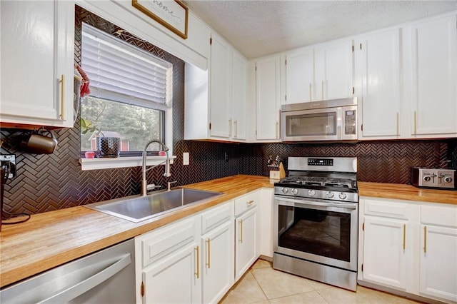 151 Quail Hollow Dr, Dallas, GA 30157 - kitchen featuring stainless steel appliances, backsplash, white cabinets, light tile patterned floors, and wooden counters