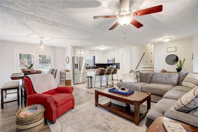151 Quail Hollow Dr, Dallas, GA 30157 - living area with light wood-style flooring, a textured ceiling, stairs, and a ceiling fan