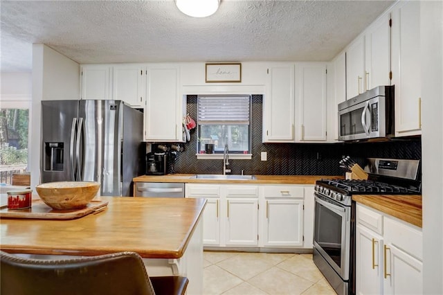 151 Quail Hollow Dr, Dallas, GA 30157 - kitchen with appliances with stainless steel finishes, butcher block countertops, plenty of natural light, decorative backsplash, and a textured ceiling