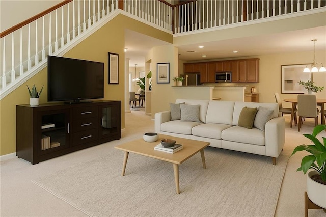 7946 Gossamer, Fairburn, GA 30213 - living room with a towering ceiling, light colored carpet, stairway, a chandelier, and recessed lighting