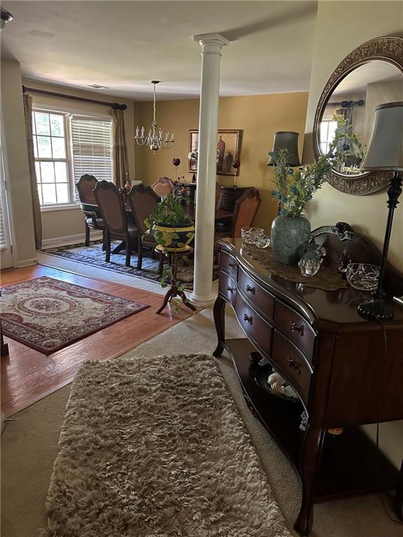 7946 Gossamer, Fairburn, GA 30213 - foyer entrance featuring ornate columns, wood finished floors, and a chandelier