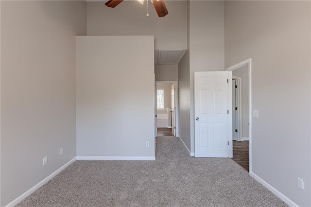 spare room featuring ceiling fan, a towering ceiling, and carpet floors