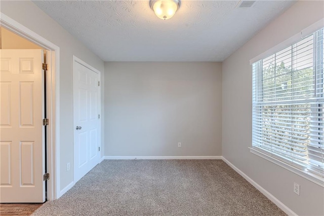 unfurnished room featuring carpet floors and a textured ceiling