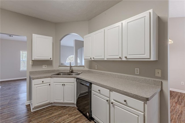 kitchen with dark wood-type flooring, sink, white cabinetry, and black dishwasher