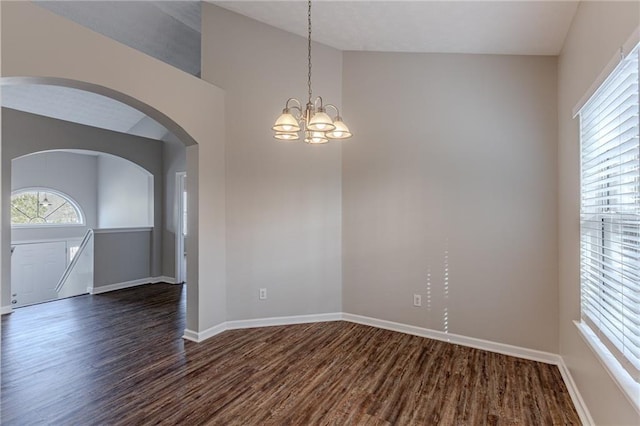 unfurnished room featuring vaulted ceiling, dark hardwood / wood-style floors, and an inviting chandelier