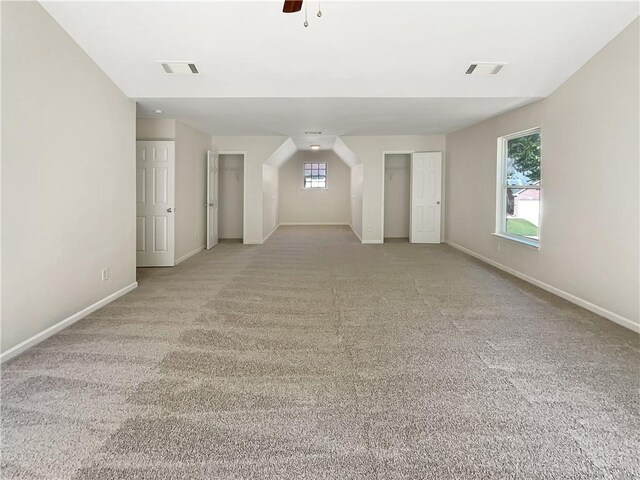 carpeted empty room with a raised ceiling and plenty of natural light