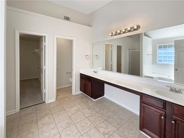 full bathroom featuring hardwood / wood-style floors, tiled shower / bath combo, vanity, and toilet