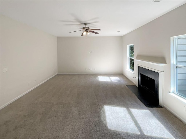 unfurnished living room featuring dark carpet and ceiling fan