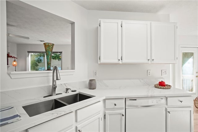 kitchen featuring a sink, a healthy amount of sunlight, white dishwasher, and white cabinetry