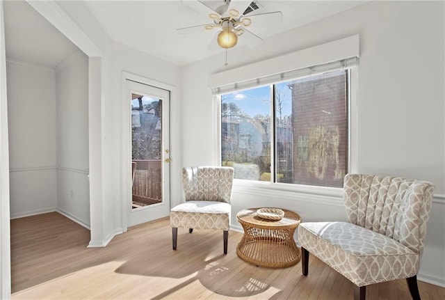 sitting room featuring baseboards, ceiling fan, and wood finished floors