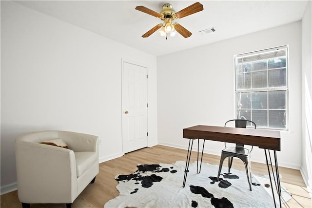 office space featuring light wood finished floors, visible vents, and baseboards