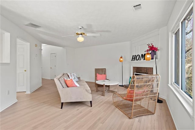 sitting room featuring plenty of natural light, a fireplace, and visible vents