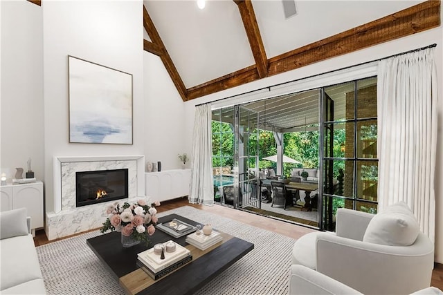 living room with wood-type flooring, a fireplace, high vaulted ceiling, and beam ceiling