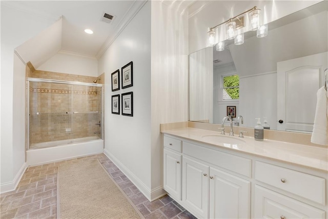 bathroom with ornamental molding, vanity, and bath / shower combo with glass door