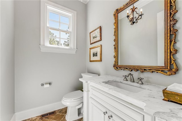 bathroom with vanity, tile patterned floors, an inviting chandelier, and toilet