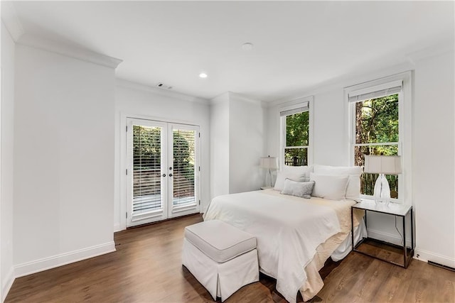 bedroom with crown molding, dark wood-type flooring, access to outside, and french doors