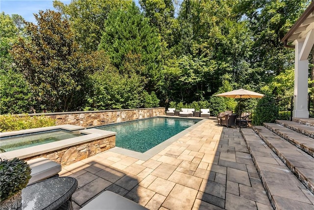 view of swimming pool featuring an in ground hot tub and a patio area