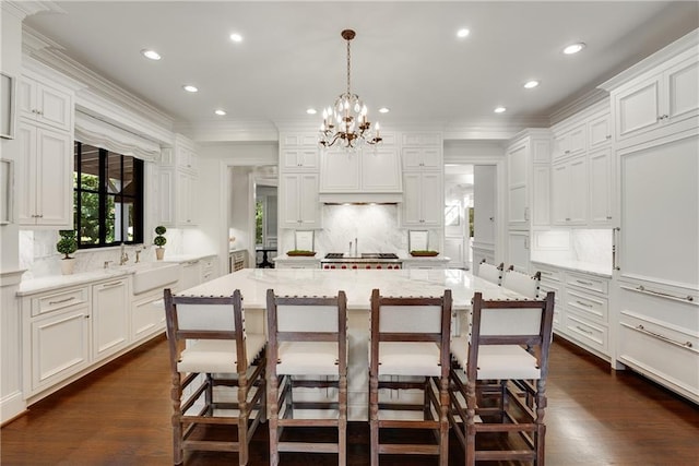 kitchen with a kitchen breakfast bar, a large island, decorative light fixtures, and sink