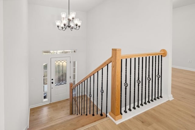 4400 Ross Estates Ct, Snellville, GA 30039 - foyer featuring a chandelier, wood finished floors, baseboards, and a high ceiling