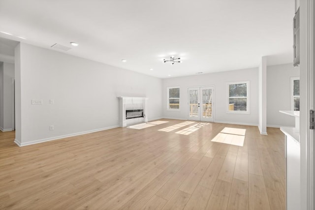 4400 Ross Estates Ct, Snellville, GA 30039 - unfurnished living room featuring french doors, light wood finished floors, a fireplace with flush hearth, baseboards, and recessed lighting