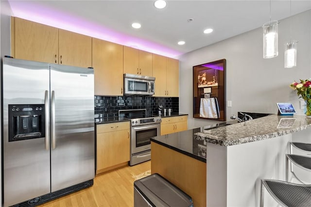400 W Peachtree St NW Unit 3711, Atlanta, GA 30308 - kitchen featuring appliances with stainless steel finishes, a peninsula, light wood-type flooring, decorative backsplash, and recessed lighting