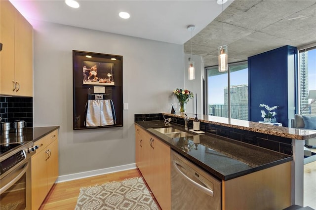 400 W Peachtree St NW Unit 3711, Atlanta, GA 30308 - kitchen featuring stainless steel appliances, a peninsula, light wood-style flooring, dark stone counters, and hanging light fixtures