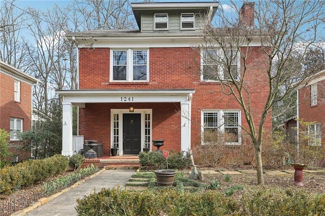 traditional style home featuring brick siding and a chimney