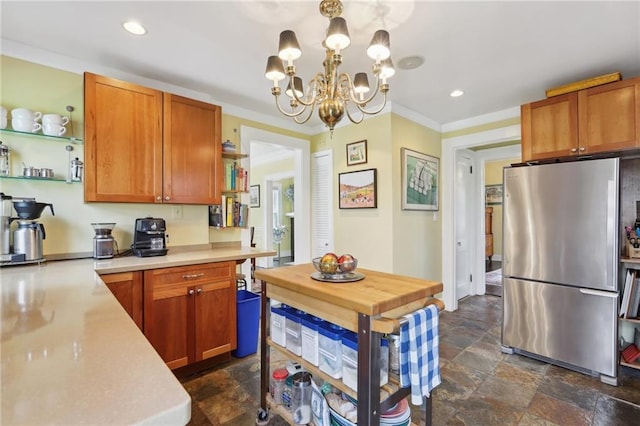 kitchen featuring stone finish flooring, light countertops, ornamental molding, freestanding refrigerator, and open shelves