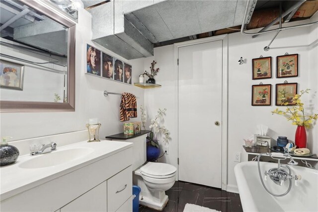 bathroom with vanity, toilet, and a bath