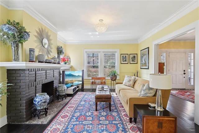 living area with ornamental molding, a fireplace, and wood finished floors