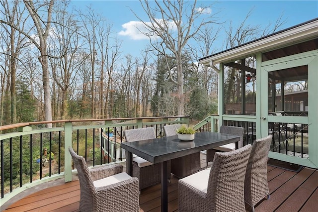 wooden deck featuring outdoor dining space and a sunroom