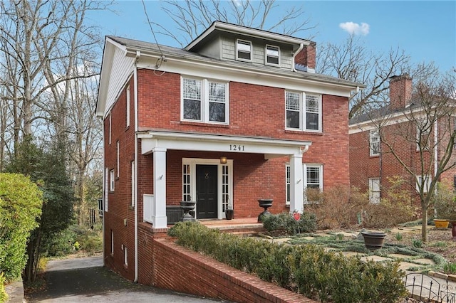 traditional style home featuring a porch and brick siding