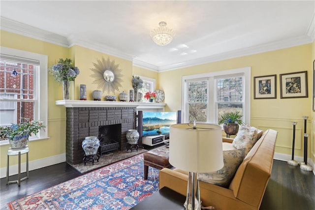 sitting room with ornamental molding, a fireplace, and wood finished floors