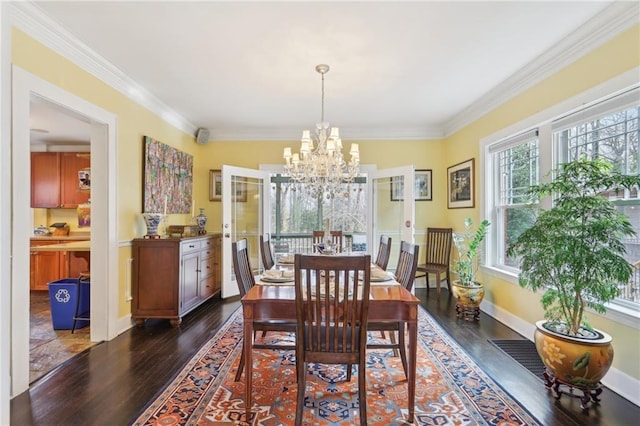 dining area featuring dark wood-style floors, crown molding, baseboards, and an inviting chandelier