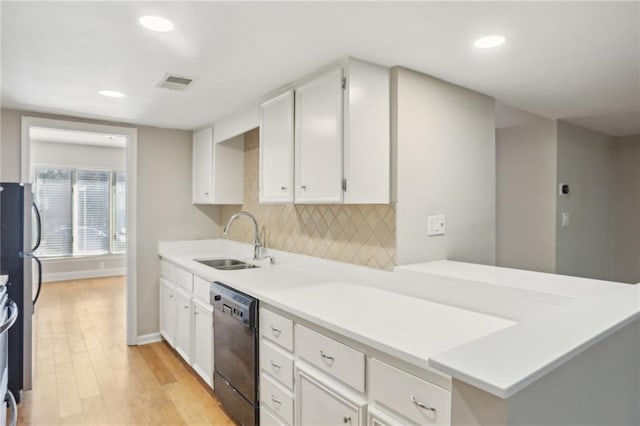 kitchen with visible vents, decorative backsplash, white cabinets, a sink, and dishwasher