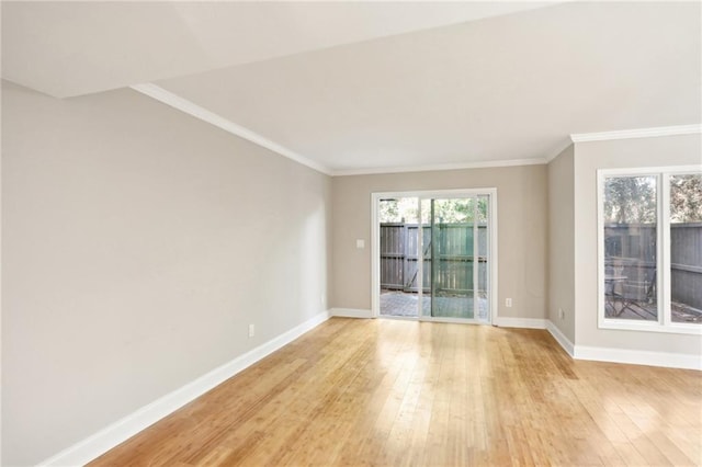 empty room featuring baseboards, crown molding, and light wood finished floors