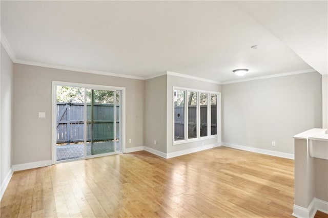 unfurnished living room featuring light wood-style floors, baseboards, and crown molding