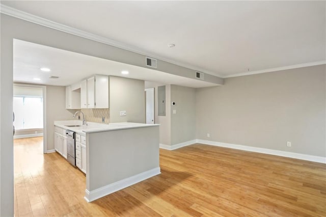 kitchen with light wood finished floors, visible vents, stainless steel dishwasher, a sink, and baseboards