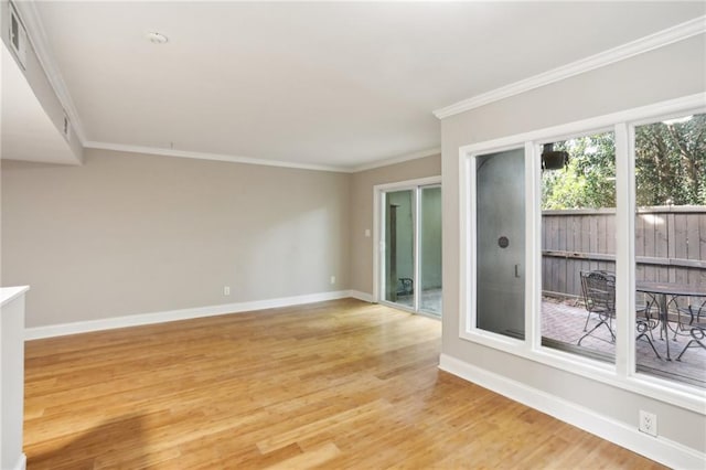 unfurnished room featuring light wood-style floors, crown molding, and baseboards