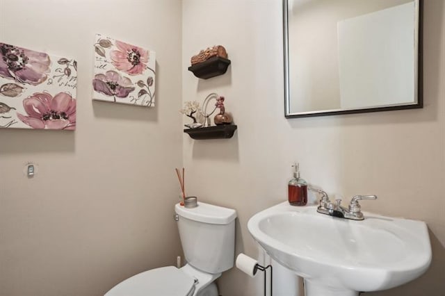 half bathroom featuring a sink and toilet