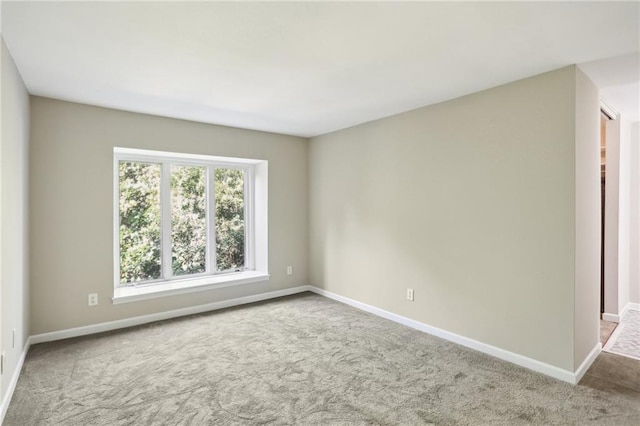 carpeted spare room with baseboards