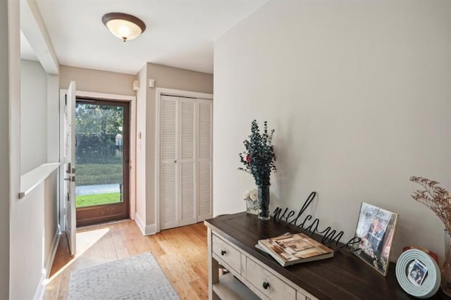 foyer with light wood finished floors and baseboards