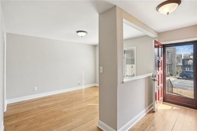 foyer with baseboards and wood finished floors