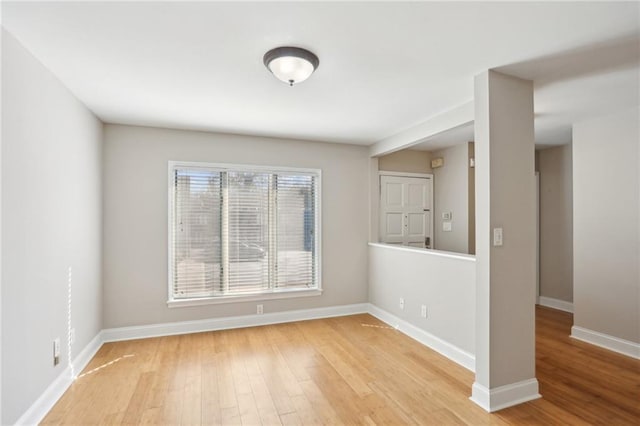 empty room with baseboards and light wood finished floors