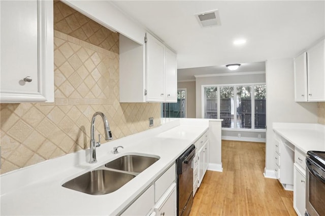 kitchen featuring a sink, visible vents, white cabinets, decorative backsplash, and black appliances