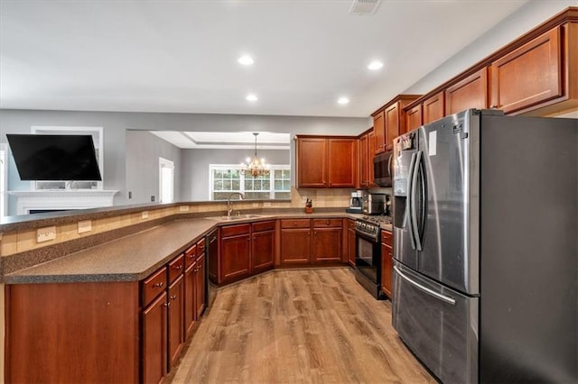4349 Kousa Rd Unit 4, Austell, GA 30106 - kitchen featuring stainless steel appliances, dark countertops, light wood finished floors, brown cabinets, and a chandelier