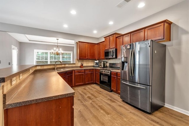 4349 Kousa Rd Unit 4, Austell, GA 30106 - kitchen with appliances with stainless steel finishes, brown cabinetry, light wood finished floors, a chandelier, and decorative backsplash